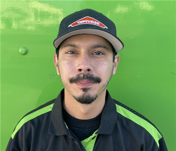 male employee standing in front of a green wall