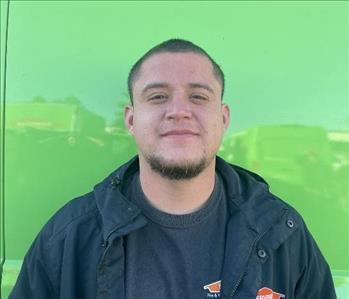 male employee standing in front of a green wall