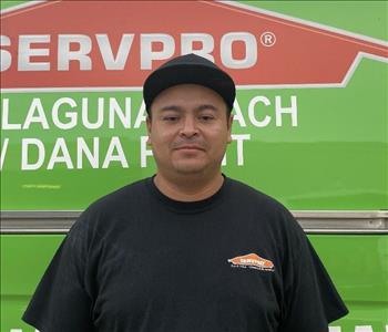 male employee standing in front of a green wall