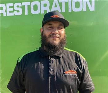 male employee standing in front of a green wall