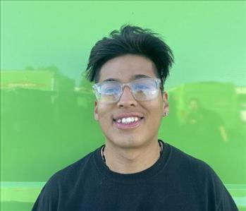 male employee standing in front of a green wall