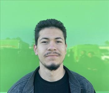 male employee standing in front of a green wall