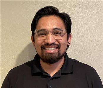 male employee standing in front of a green wall