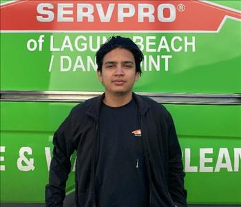 male employee standing in front of a green wall