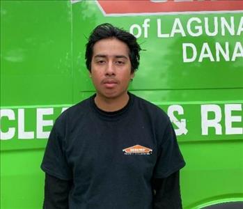 male employee standing in front of a green wall