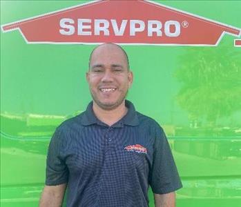 male employee standing in front of a green wall