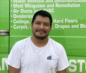 male employee standing in front of a green wall